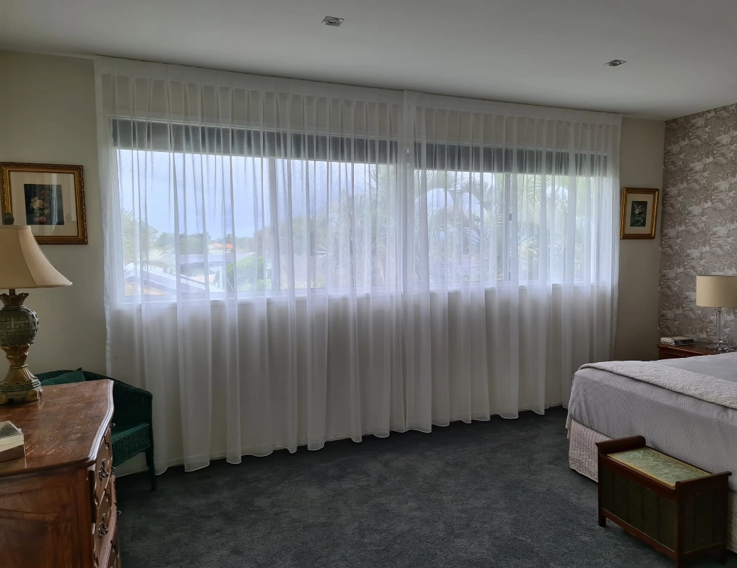Ceiling to floor sheer curtains in a bedroom