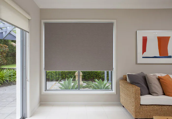 Grey blockout roller blind fitted over a living room window