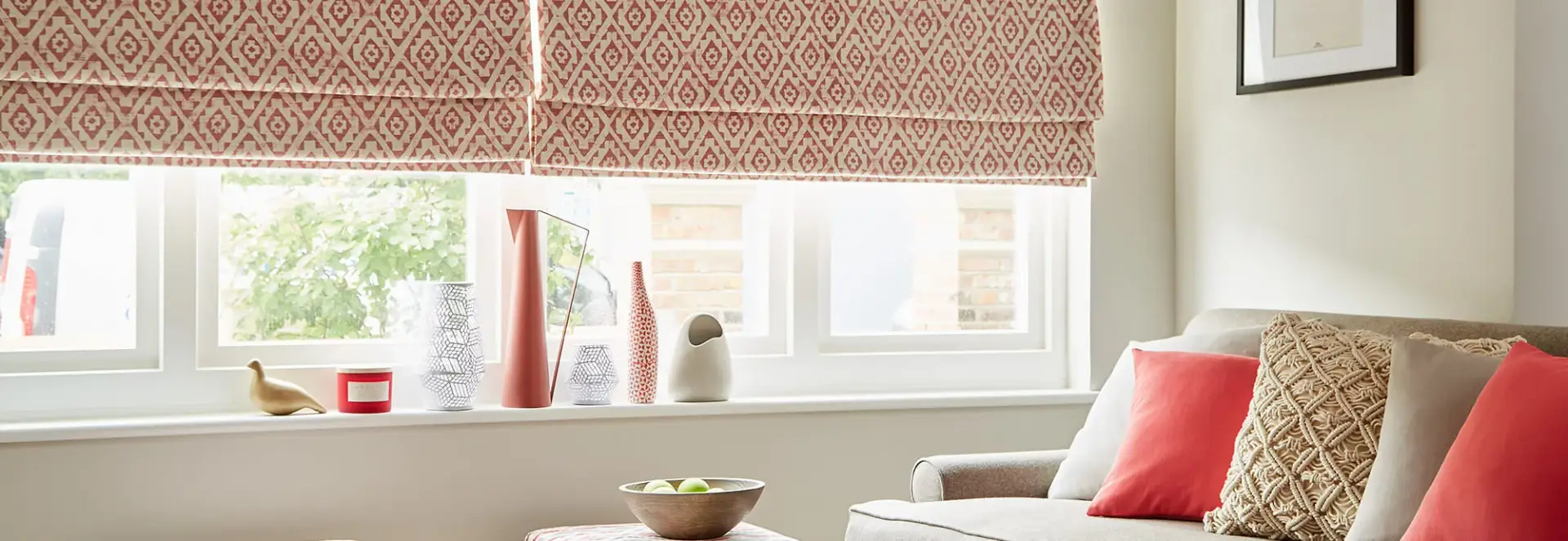 Patterned Roman blind above a bright living room window