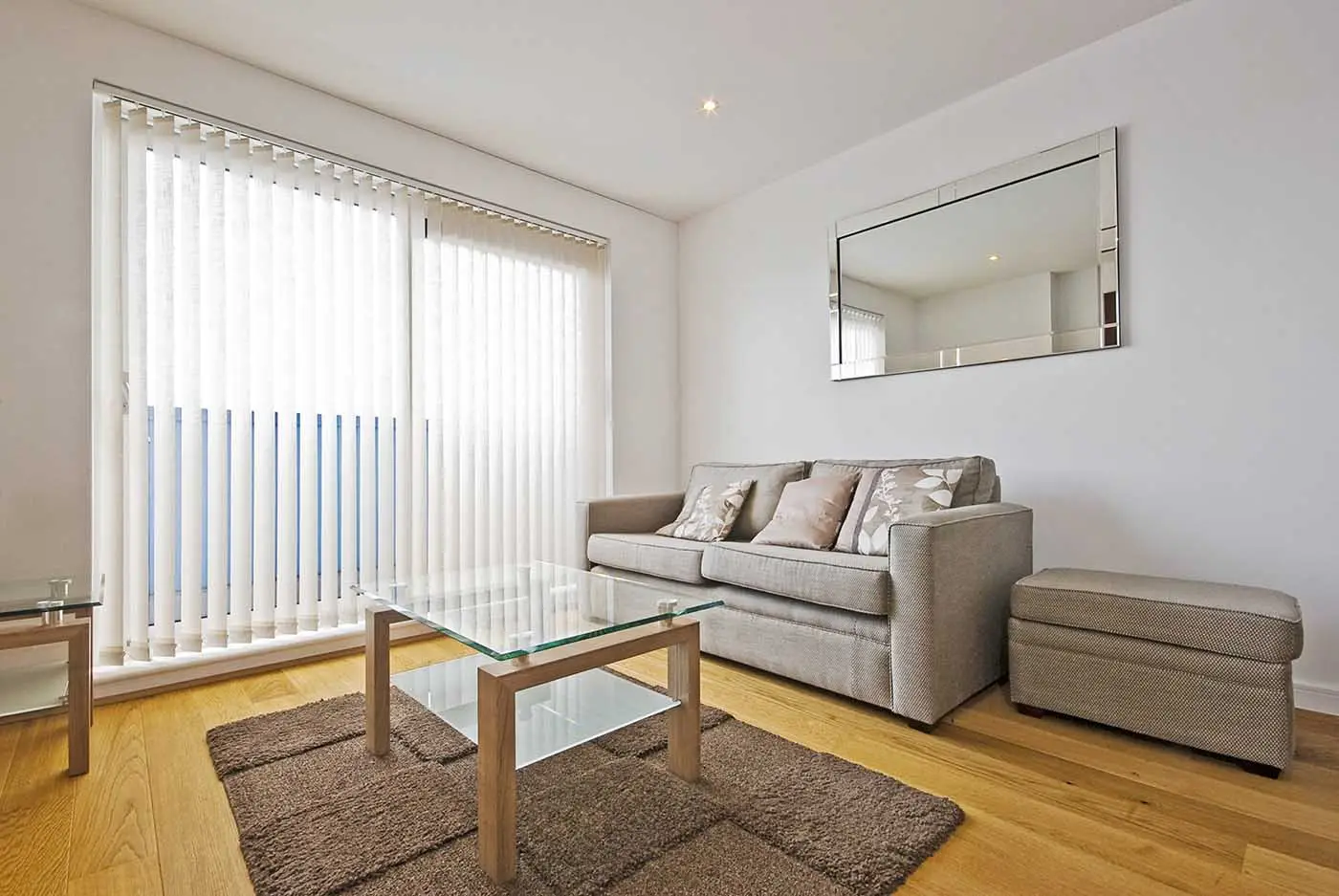 Vertical blinds installed across a sliding door in a bright living room